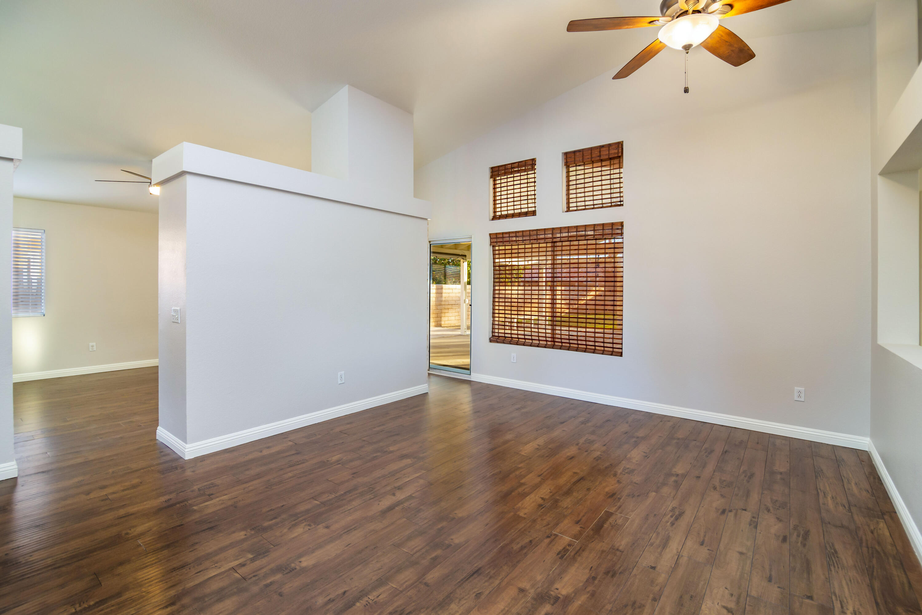 80265 Moonshadow Drive Indio, CA 92201 - Photo 24 of 32 an empty room with wooden floor chandelier fan and windows