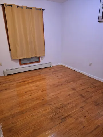 a view of a room with wooden floor and cabinet