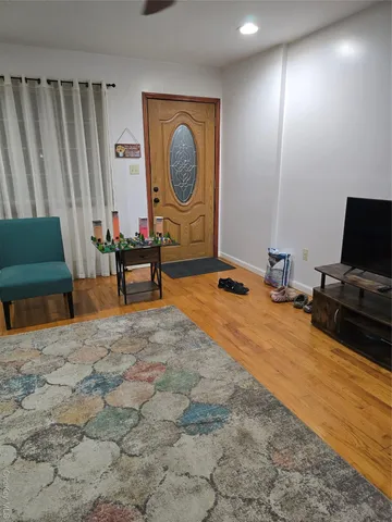 a bedroom with a bed and a chair with the wooden floor