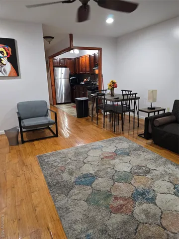 a living room with furniture a flat screen tv and kitchen view