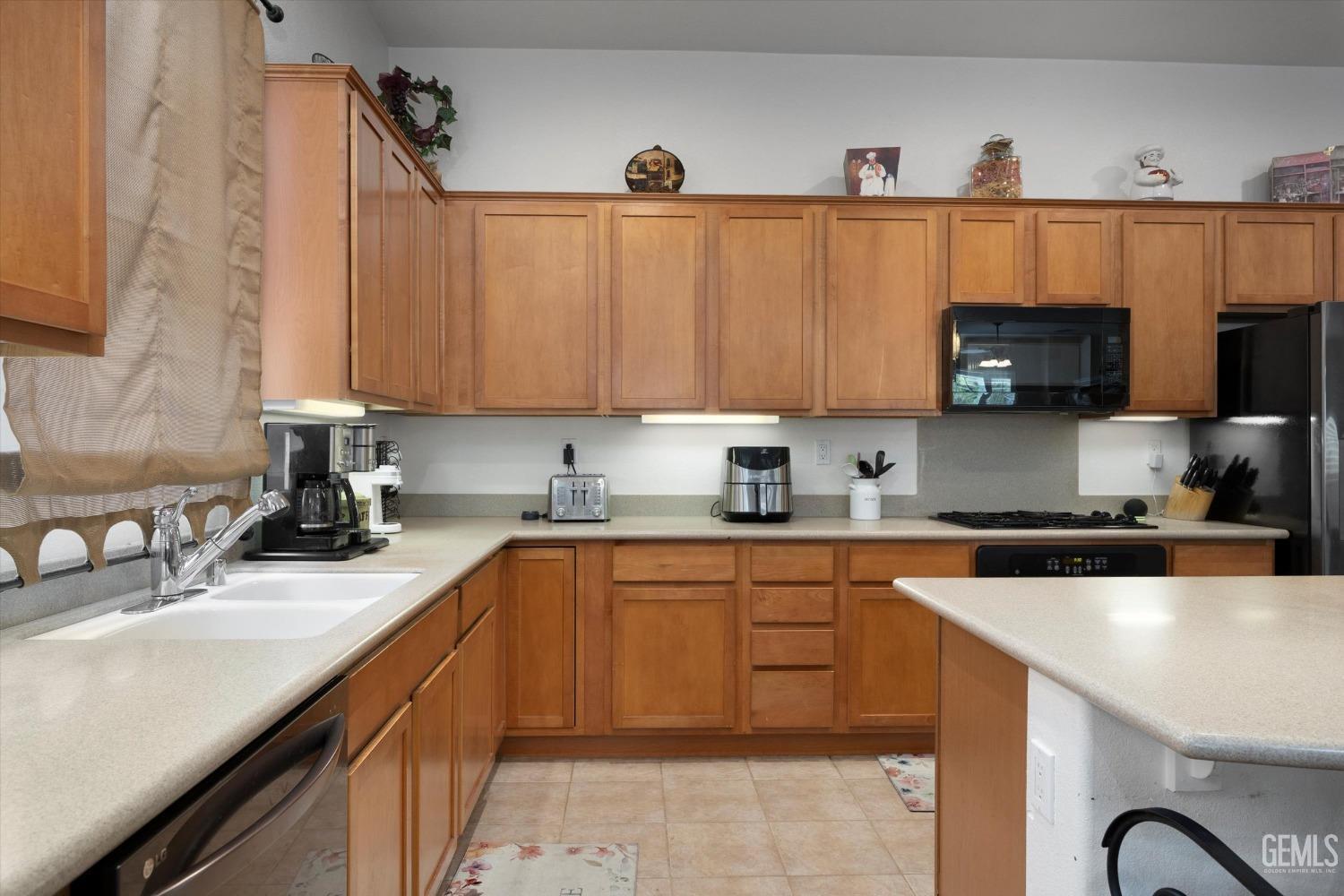Undisclosed Address Bakersfield, CA 93306 - Photo 23 of 48 a kitchen with granite countertop a sink a stove and a microwave oven