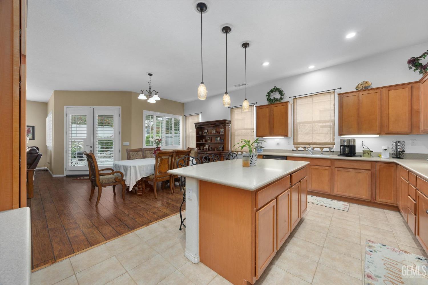 Undisclosed Address Bakersfield, CA 93306 - Photo 27 of 48 a large kitchen with kitchen island a sink a stove a dining table and chairs