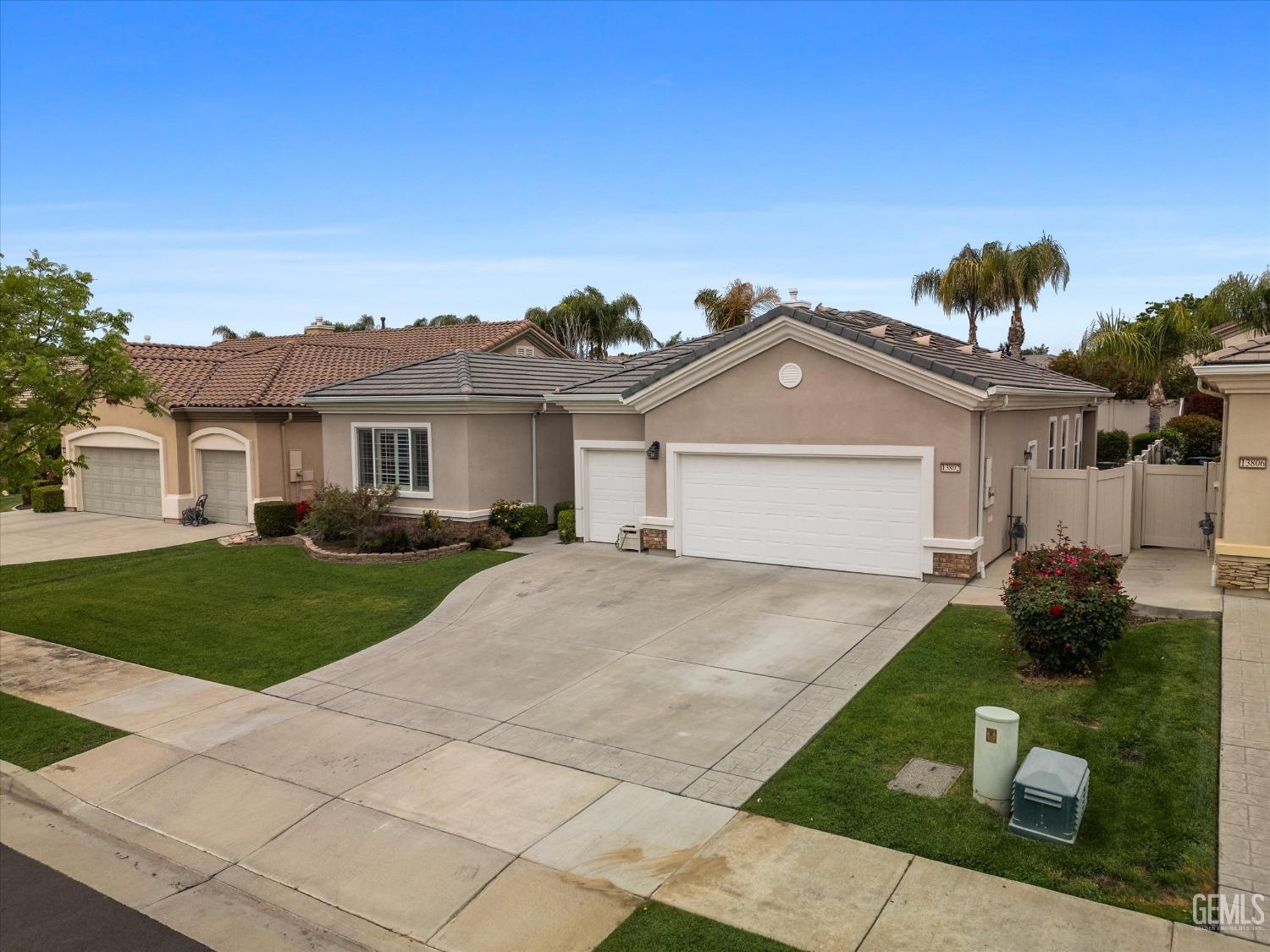 Undisclosed Address Bakersfield, CA 93306 - Photo 5 of 48 a front view of a house with a yard and garage