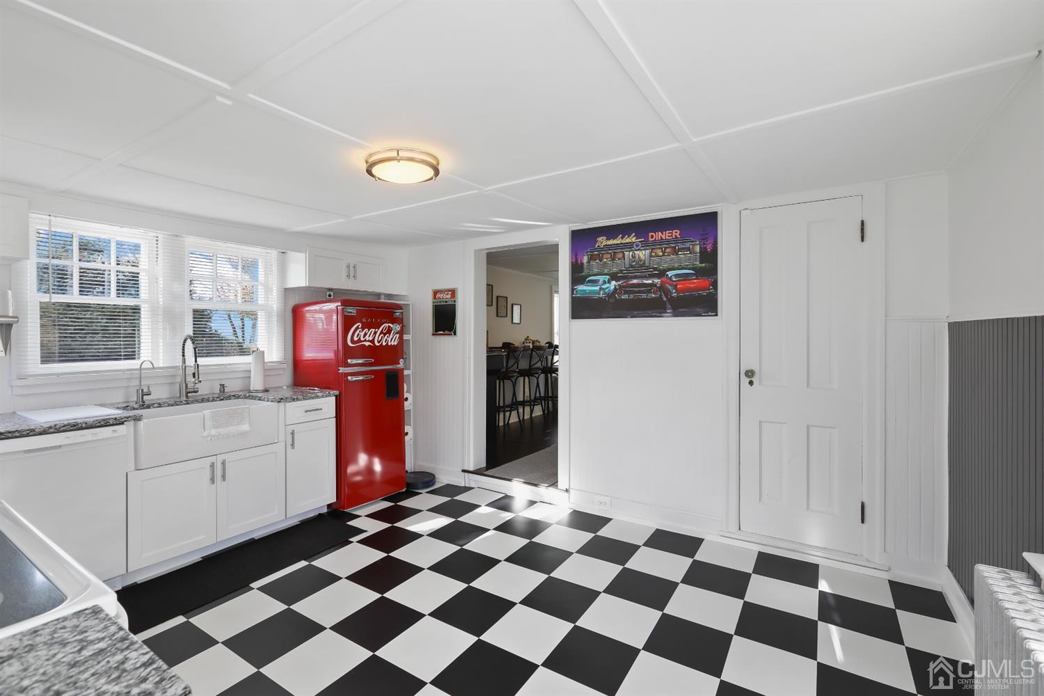 385 Ridge Road Dayton, NJ 08810 - Photo 5 of 29 a kitchen with a checkered floor and white cabinets