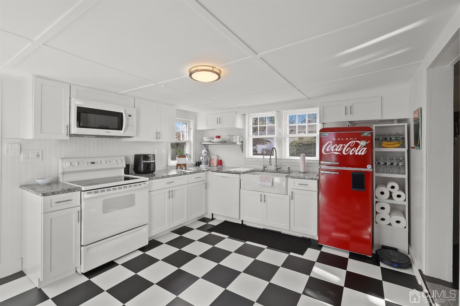 385 Ridge Road Dayton, NJ 08810 - Photo 8 of 29 a kitchen with a checkered floor and white cabinets