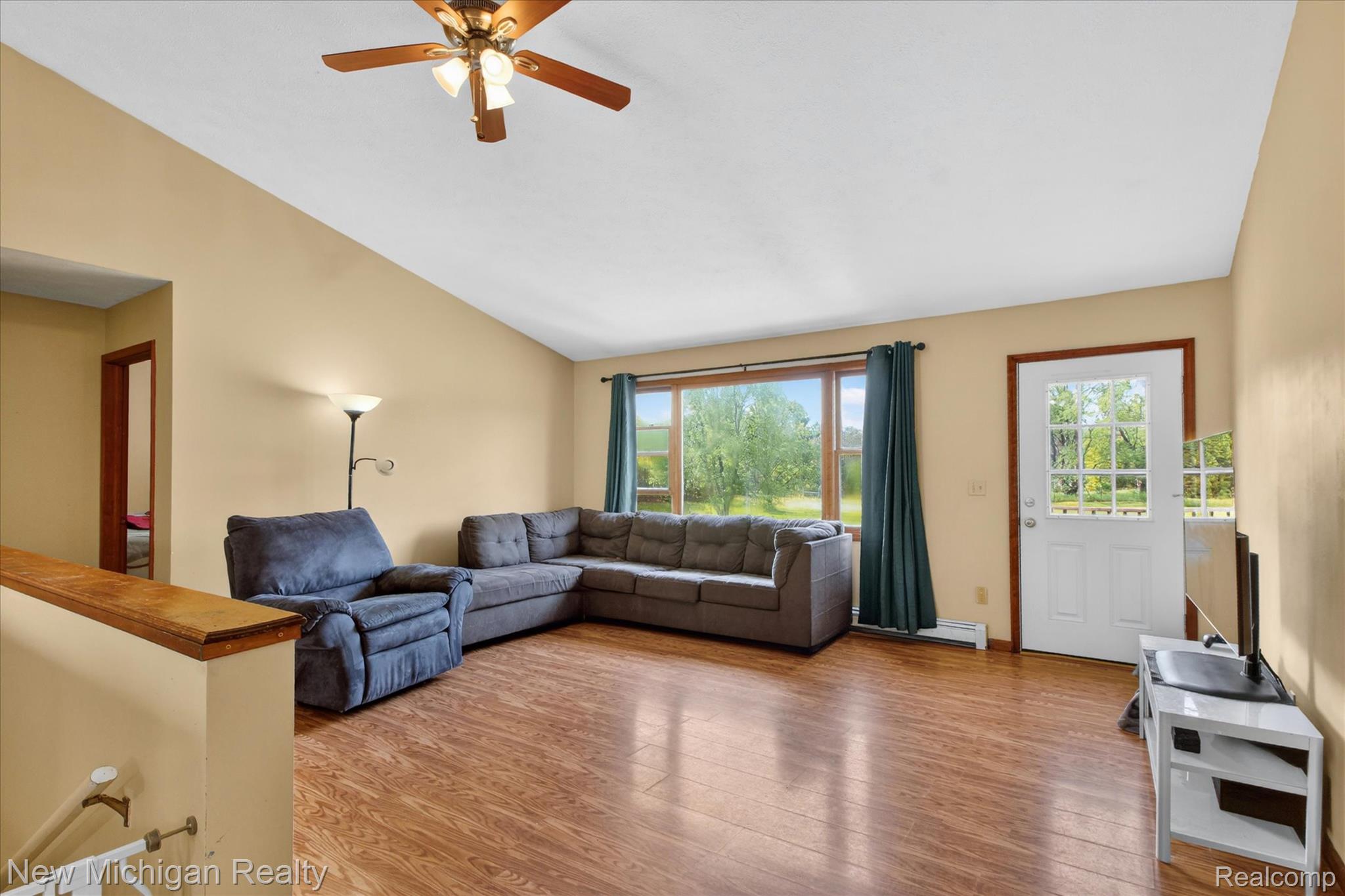 22623 11 Mile Road Reed City, MI 49677 - Photo 10 of 47 Spacious living area featuring wood-finish flooring, vaulted ceilings, and a ceiling fan