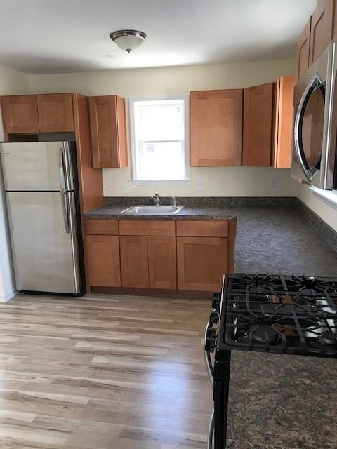 19 Stanton Road Brooklyn, NY 11235 - Photo 8 of 12 a kitchen with wooden cabinets and a stove top oven