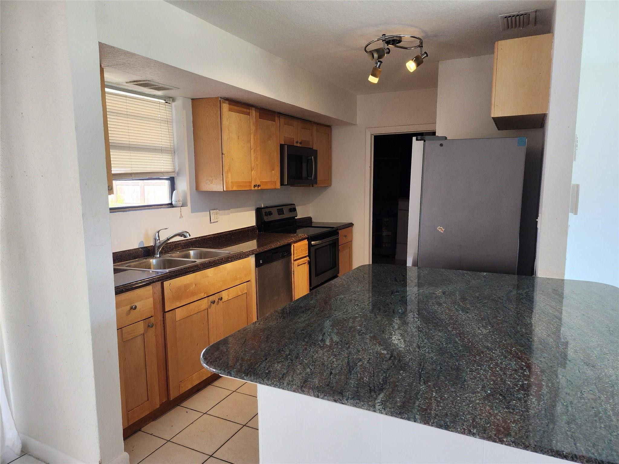 704 Southwest 4th Street Hallandale Beach, FL 33009 - Photo 15 of 33 a kitchen with granite countertop a stove a sink and a refrigerator