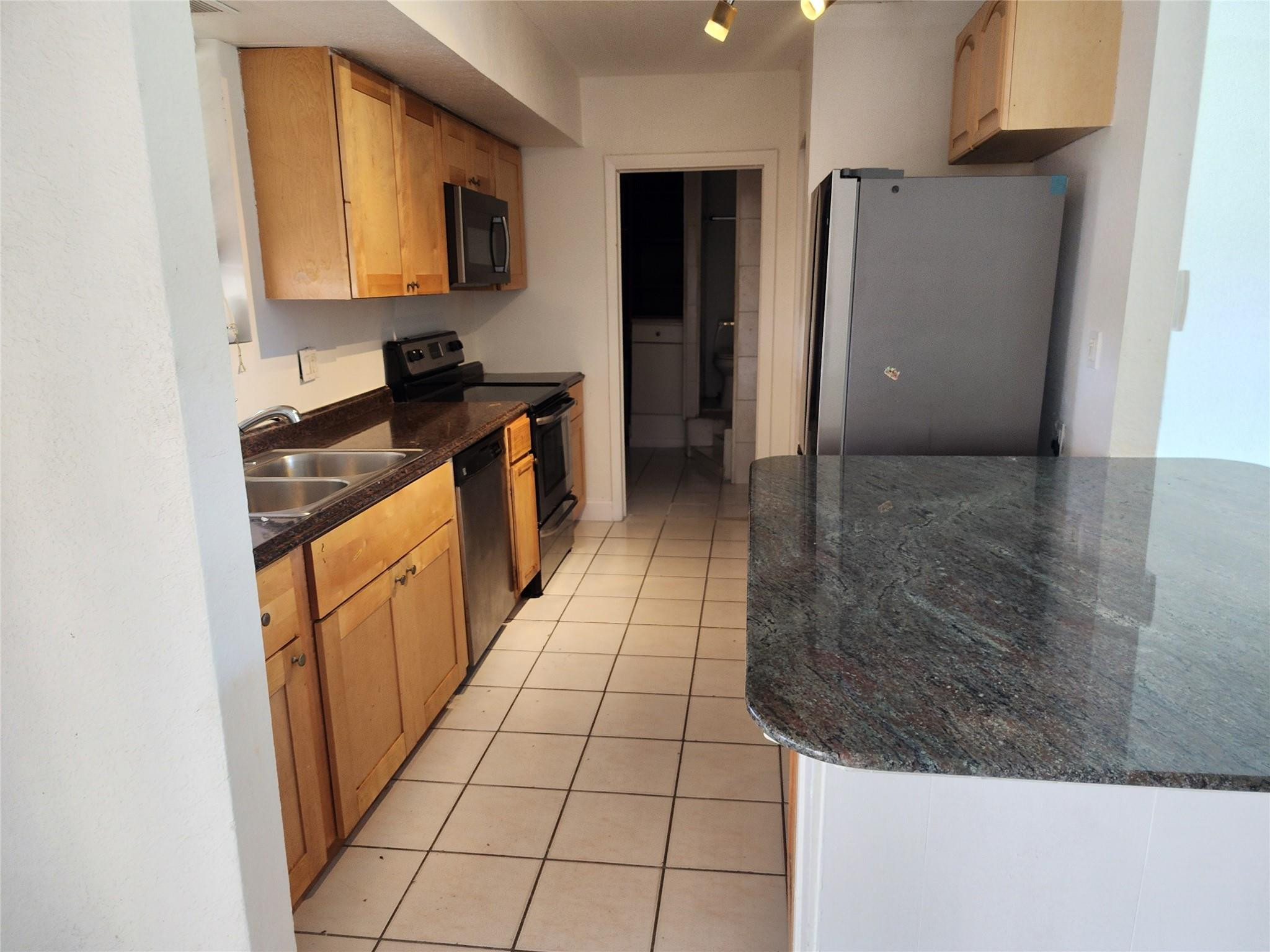 704 Southwest 4th Street Hallandale Beach, FL 33009 - Photo 16 of 33 a kitchen with stainless steel appliances a sink stove and refrigerator