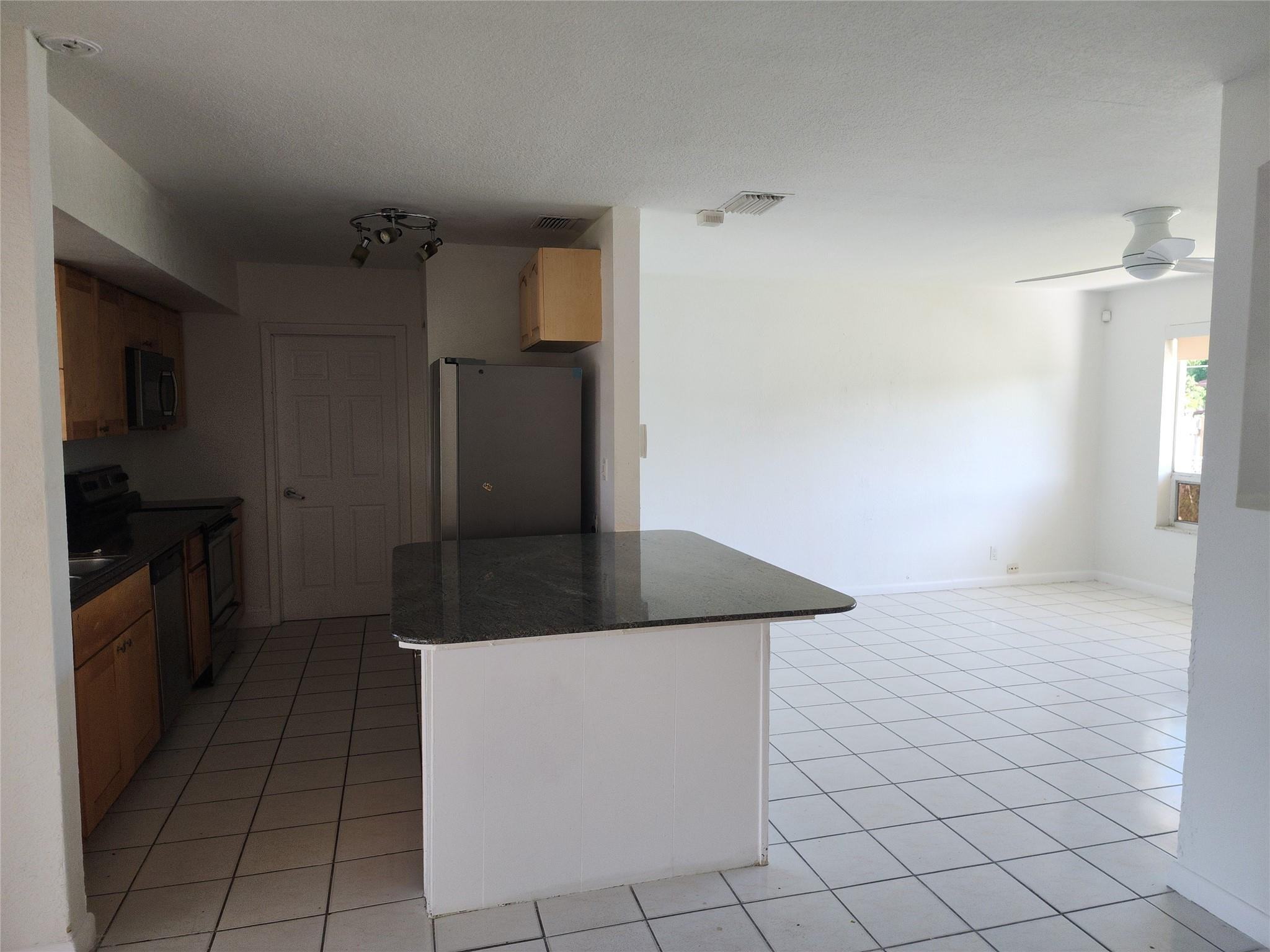 704 Southwest 4th Street Hallandale Beach, FL 33009 - Photo 28 of 33 a kitchen with stainless steel appliances granite countertop a sink and a refrigerator
