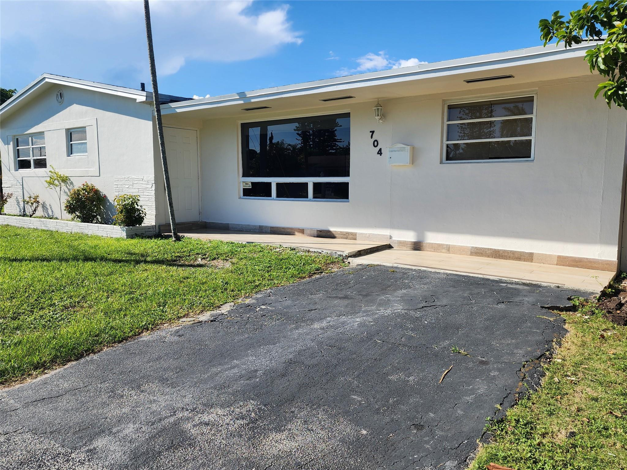 704 Southwest 4th Street Hallandale Beach, FL 33009 - Photo 30 of 33 a front view of a house with a yard and garage