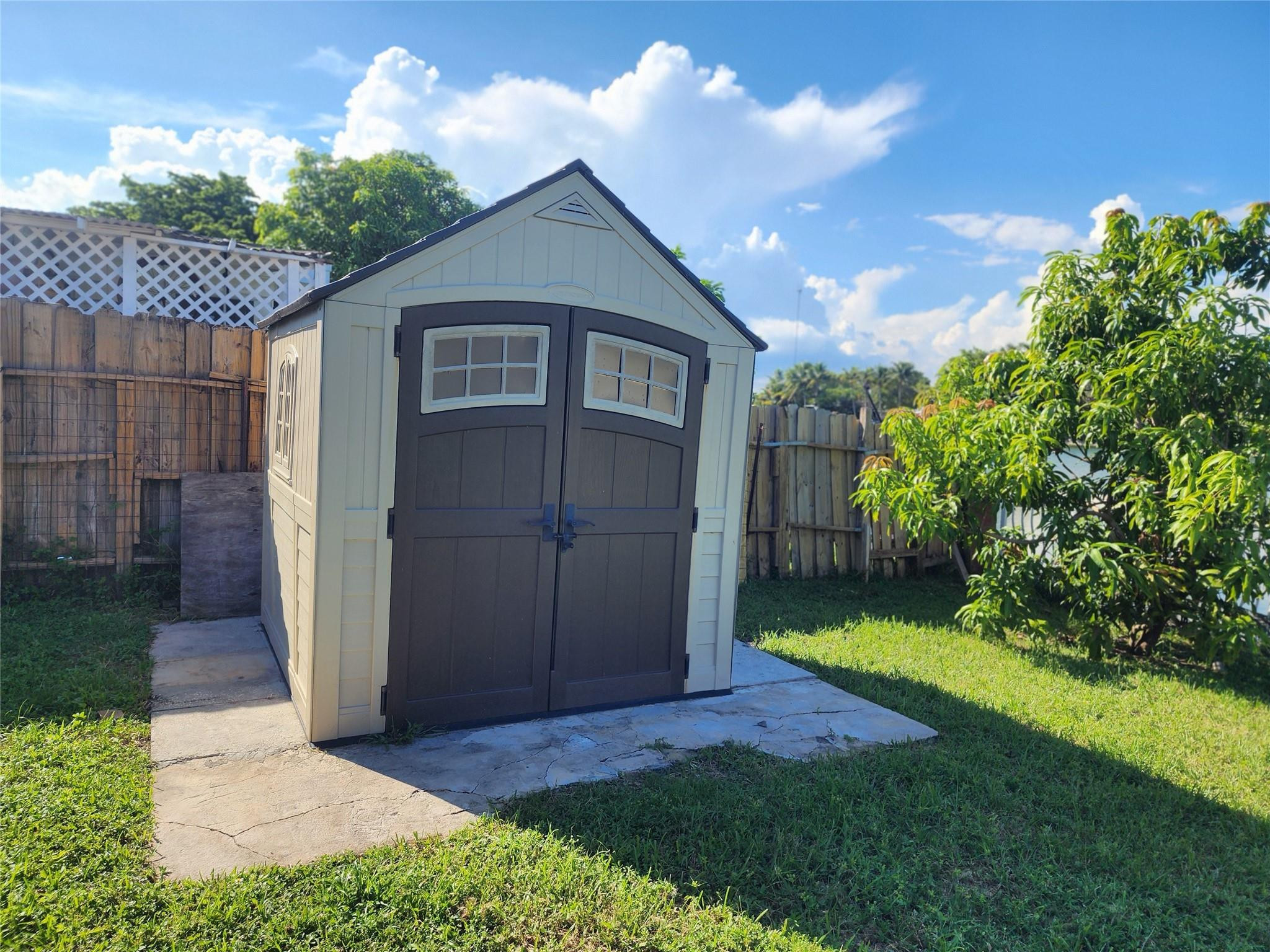 704 Southwest 4th Street Hallandale Beach, FL 33009 - Photo 10 of 33 a view of a small house with a small yard and a large tree