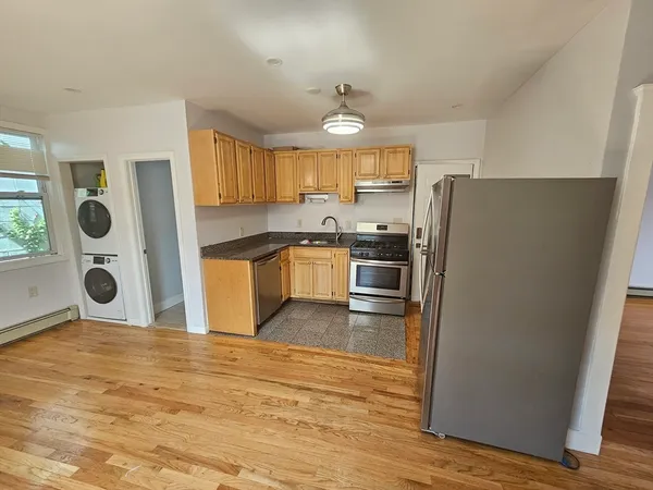 a kitchen with stainless steel appliances granite countertop a refrigerator a stove top oven a sink and dishwasher