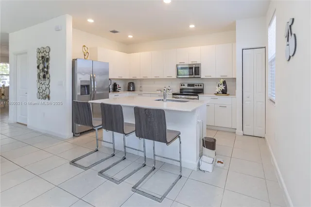 a kitchen with stainless steel appliances a refrigerator sink and microwave