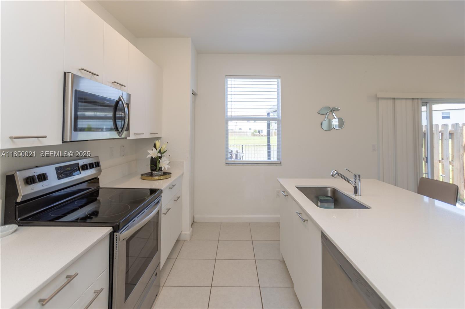 12561 Northwest 23rd Place Miami, FL 33167 - Photo 14 of 45 a kitchen that has a sink and a stove