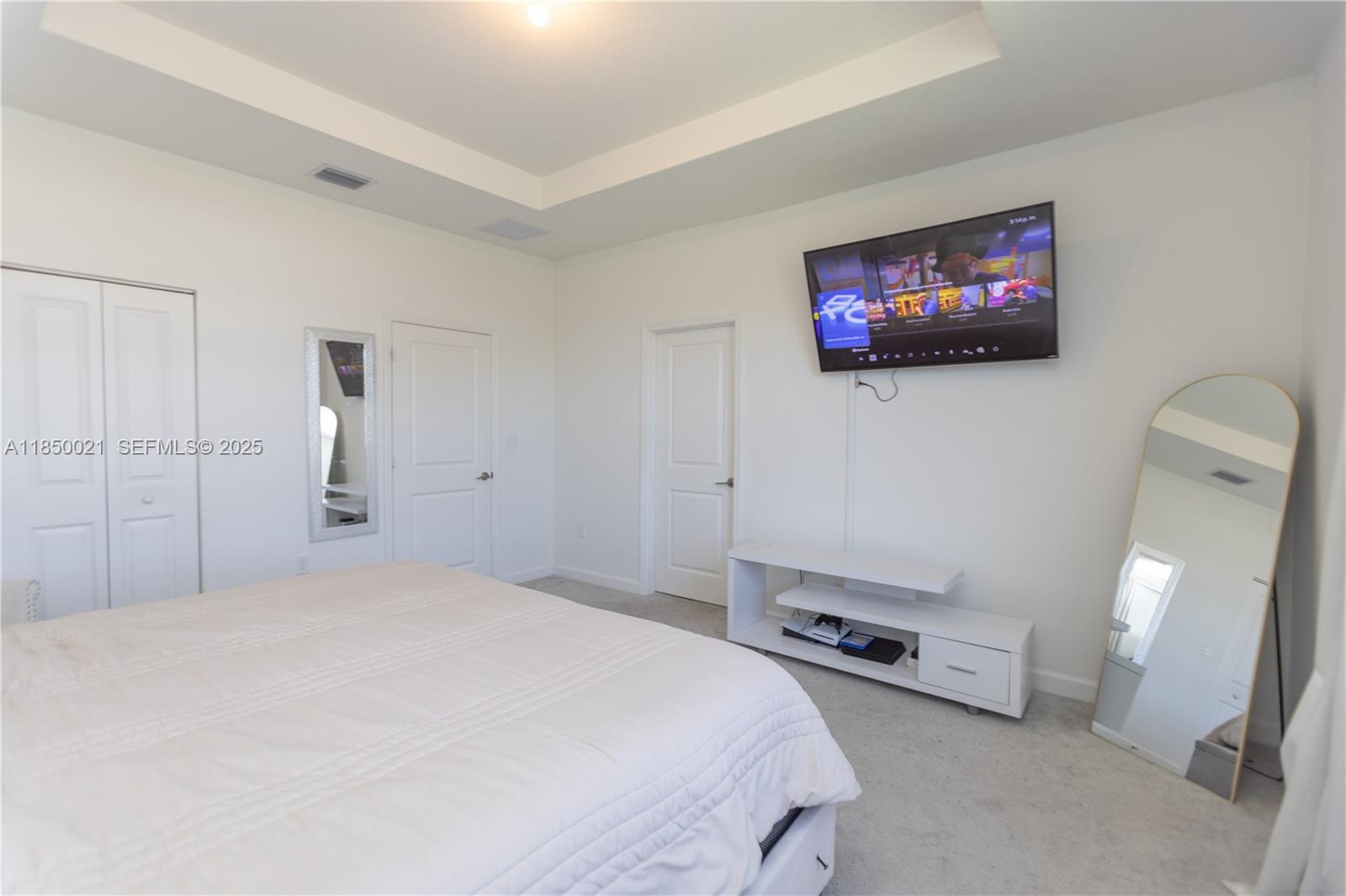 12561 Northwest 23rd Place Miami, FL 33167 - Photo 20 of 45 a bedroom with a bed and a flat screen tv