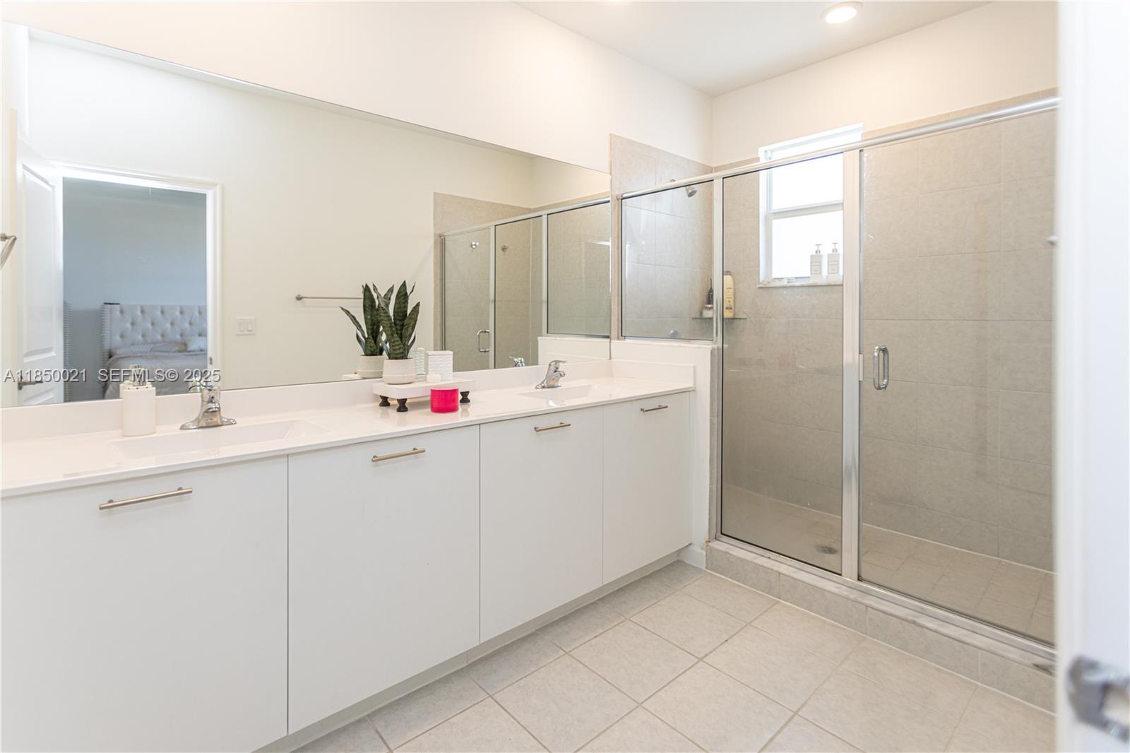 12561 Northwest 23rd Place Miami, FL 33167 - Photo 22 of 45 a bathroom with a shower sink and mirror