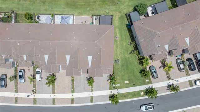 an aerial view of a house with a yard and a car parked