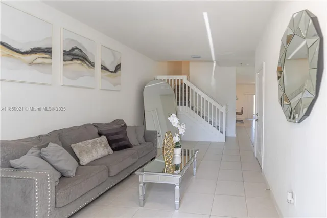 a living room with furniture and a painting on the wall