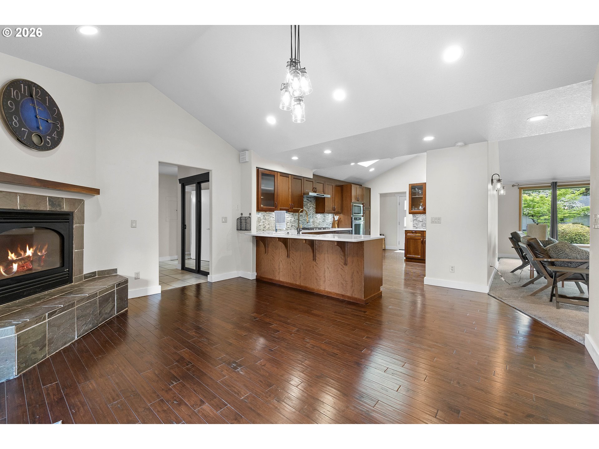11465 Southwest 92nd Avenue Portland, OR 97223 - Photo 12 of 47 a living room with stainless steel appliances kitchen island a fireplace furniture a stove and wooden floor