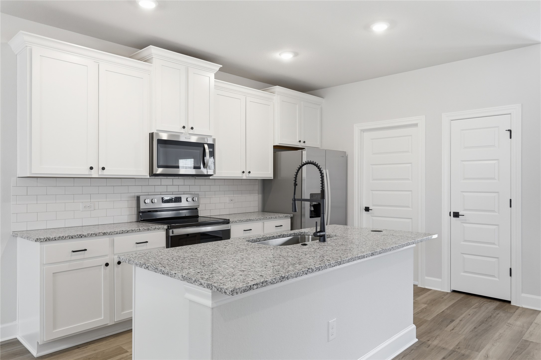 9320 Gladsome Path Manor, TX 78653 - Photo 20 of 34 a kitchen with stainless steel appliances granite countertop a sink a stove a microwave and cabinets