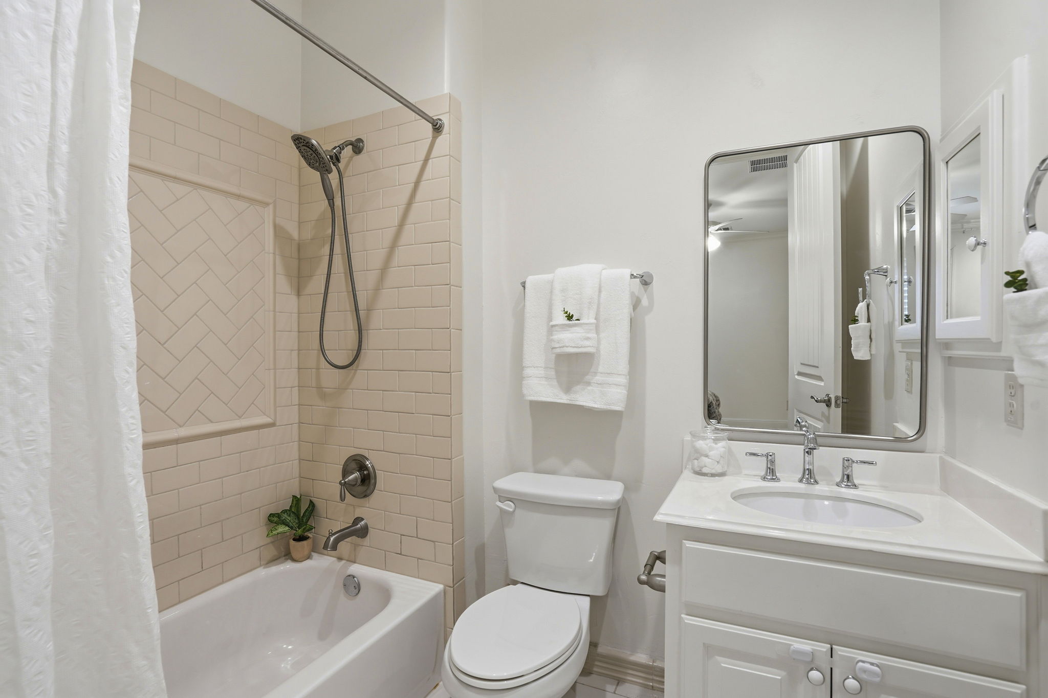 2420 Legend Trail Leander, TX 78641 - Photo 23 of 40 Warm and inviting, this bathroom features classic subway tile with a unique herringbone inset, bringing texture and character to the shower-tub combo. The clean white vanity and brushed nickel hardware offer a timeless look that guests will love.