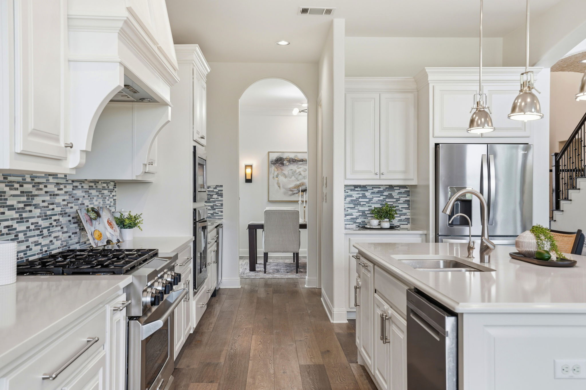 2420 Legend Trail Leander, TX 78641 - Photo 9 of 40 Featuring a massive quartz island with a breakfast bar, professional-grade stainless steel appliances and a mosaic tile backsplash.