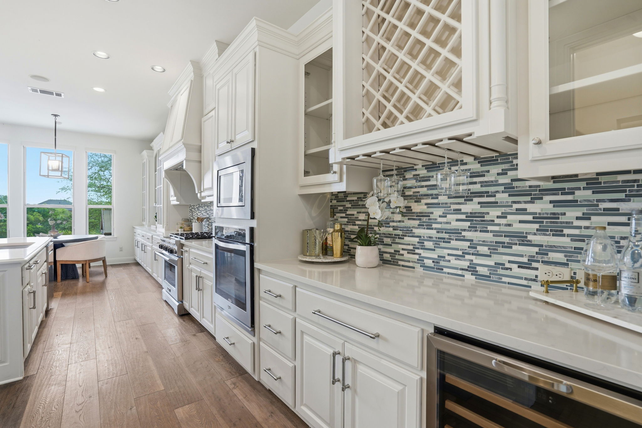 2420 Legend Trail Leander, TX 78641 - Photo 10 of 40 Entertainer’s dream! This dedicated beverage station features a built-in wine rack, glass-front cabinetry, and a sleek wine fridge. The intricate mosaic backsplash adds a splash of cool-toned texture to the crisp white woodwork.