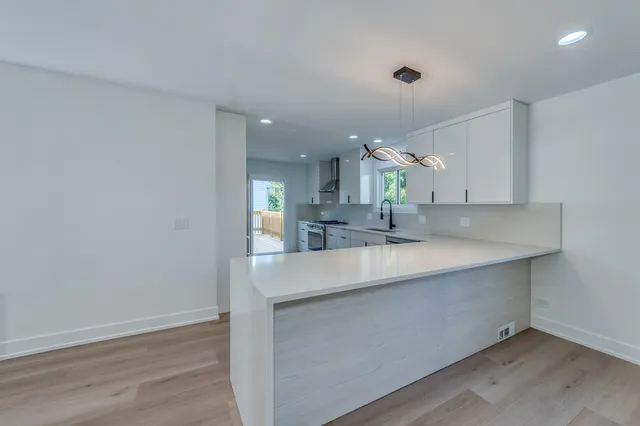 a kitchen with kitchen island a sink stainless steel appliances and cabinets