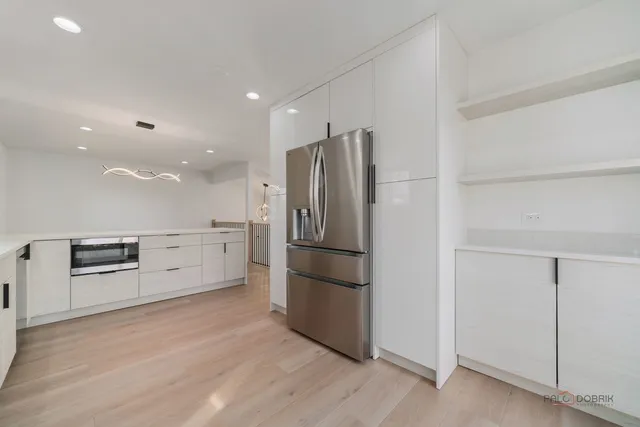 a kitchen with stainless steel appliances a refrigerator and a stove top oven