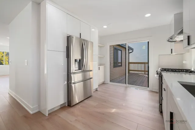 a kitchen with stainless steel appliances a refrigerator and a stove top oven