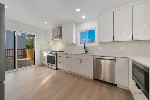 a kitchen with stainless steel appliances granite countertop a sink a stove and cabinets