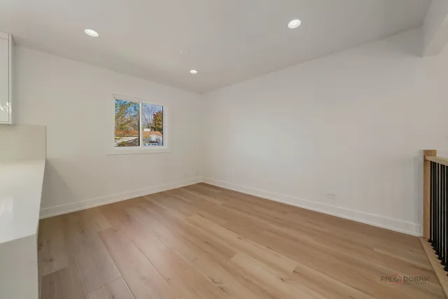 an empty room with wooden floor and window