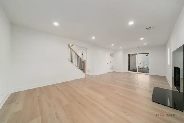 a view of empty room with wooden floor and fireplace