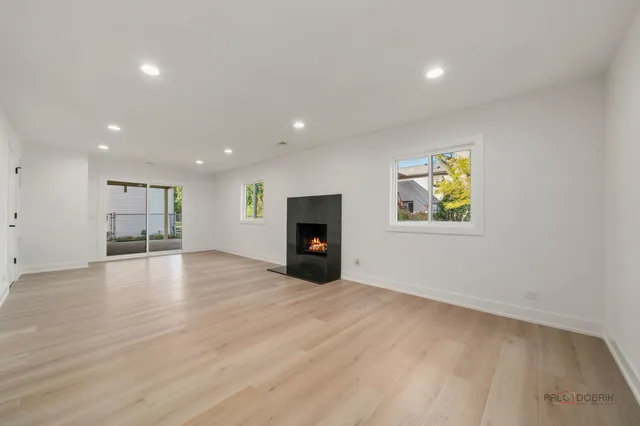 an empty room with wooden floor and natural light