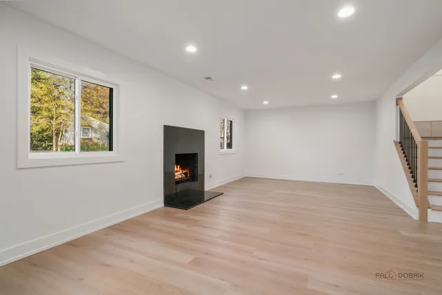 a view of an empty room with a fireplace and a window
