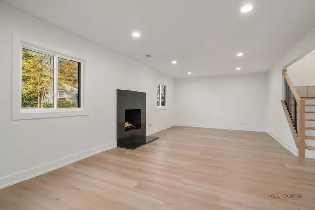 a view of an empty room with a fireplace and a window