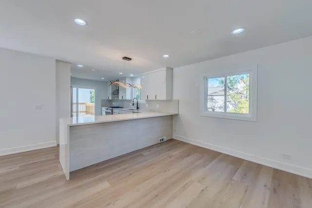 a large kitchen with stainless steel appliances a large counter top a sink and a window