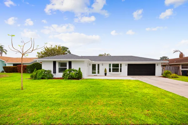 a front view of a house with a garden and yard