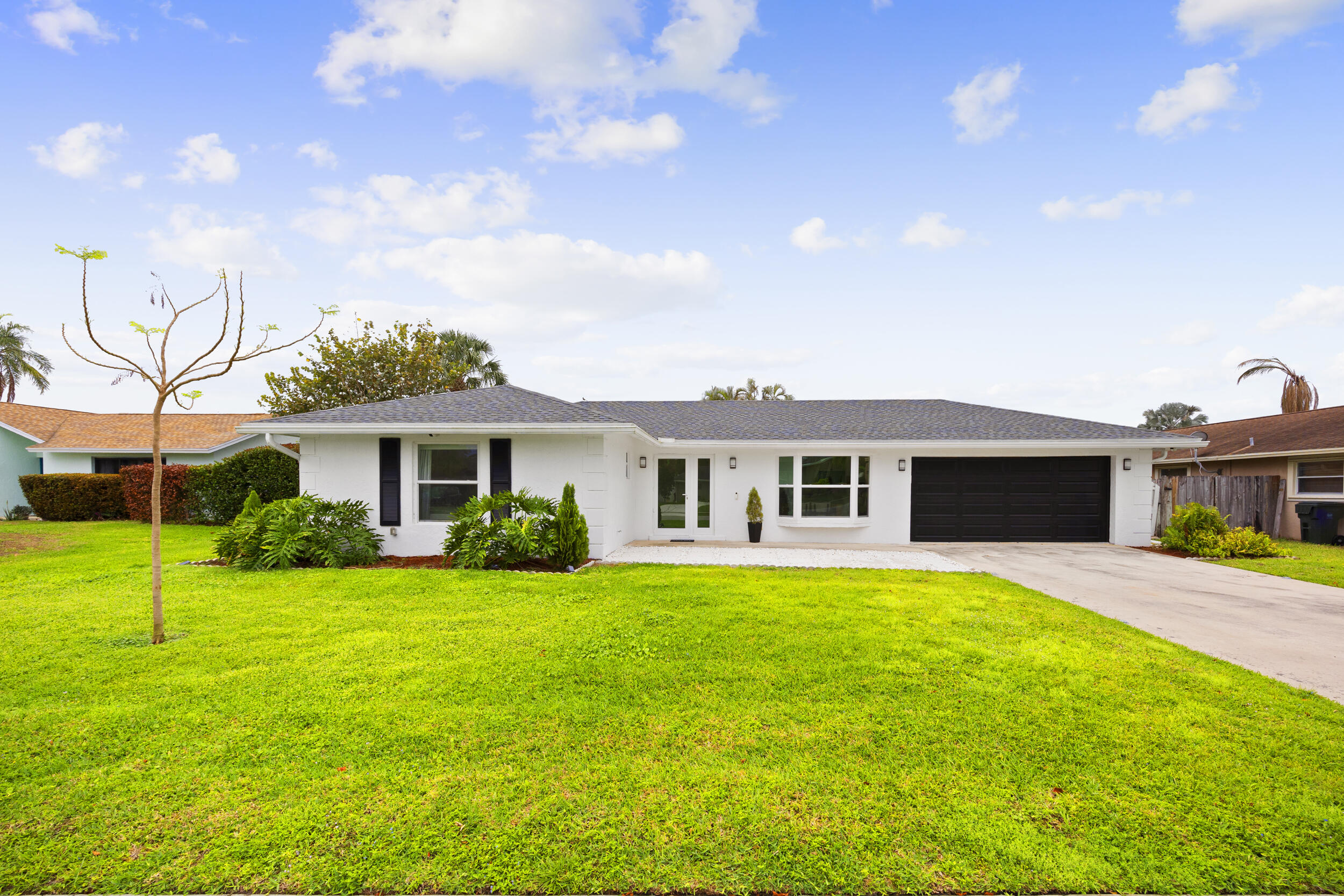 a front view of a house with a garden and yard