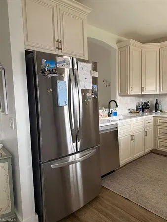 a kitchen with a refrigerator sink and cabinets