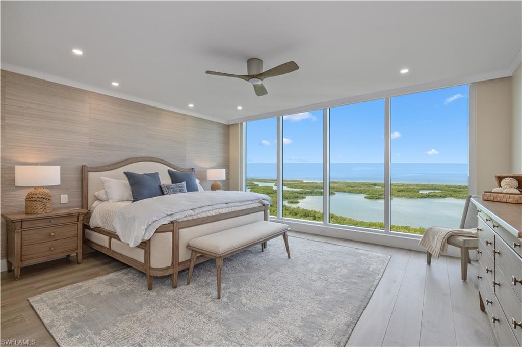 a bedroom with a bed and large glass window