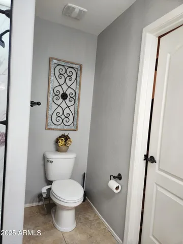 a white toilet sitting next to a bathroom sink and a mirror