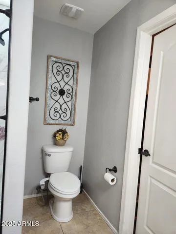 a white toilet sitting next to a bathroom sink and vanity
