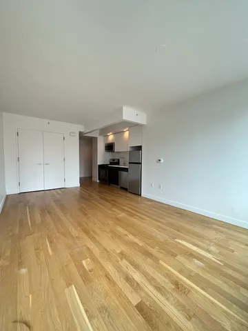 a view of empty room with a fireplace and wooden floor