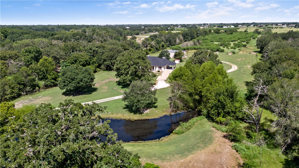 an aerial view of a house with a yard and lake view