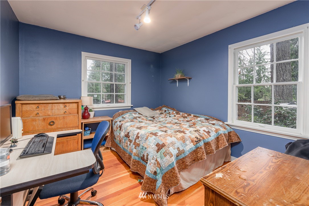 4004 Cooper Point Road Northwest Olympia, WA 98502 - Photo 15 of 28 a bedroom with a bed a table and windows