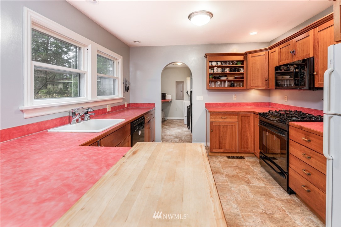 4004 Cooper Point Road Northwest Olympia, WA 98502 - Photo 7 of 28 a room with stainless steel appliances kitchen island granite countertop a stove and a sink