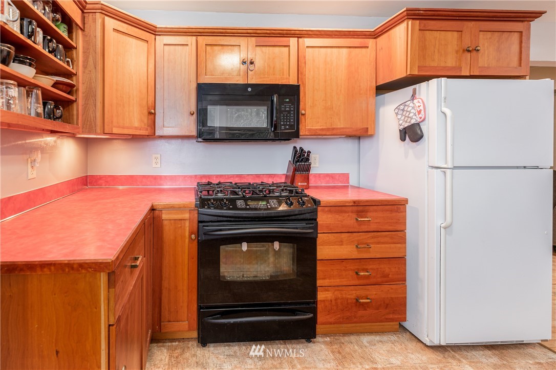 4004 Cooper Point Road Northwest Olympia, WA 98502 - Photo 9 of 28 a kitchen with stainless steel appliances a stove a microwave and a refrigerator