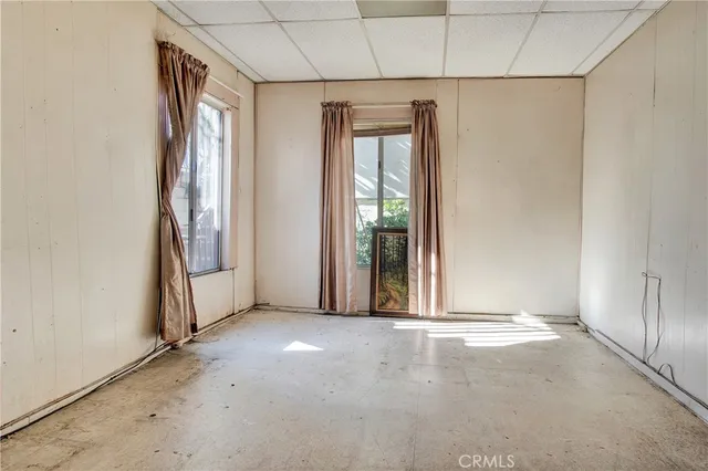 a dining room with furniture and a floor to ceiling window